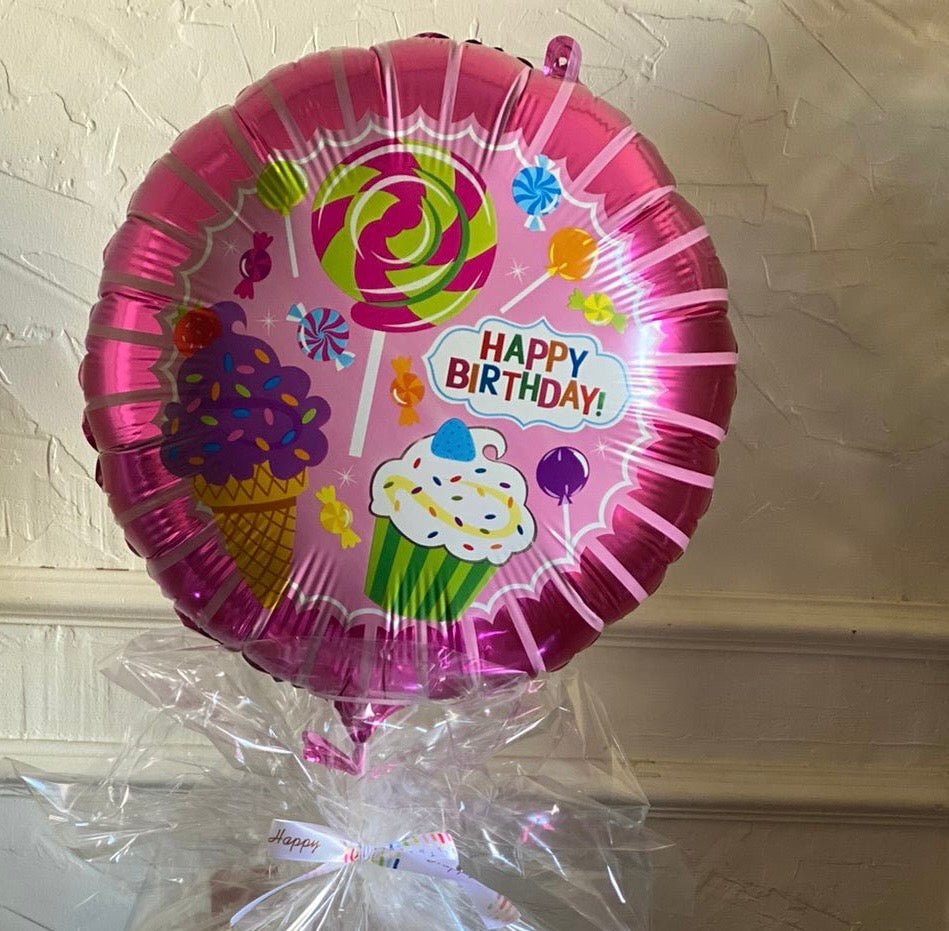 A pink Happy Birthday balloon decorated with colorful candy and cupcake illustrations, adding a festive and cheerful touch to any birthday celebration.