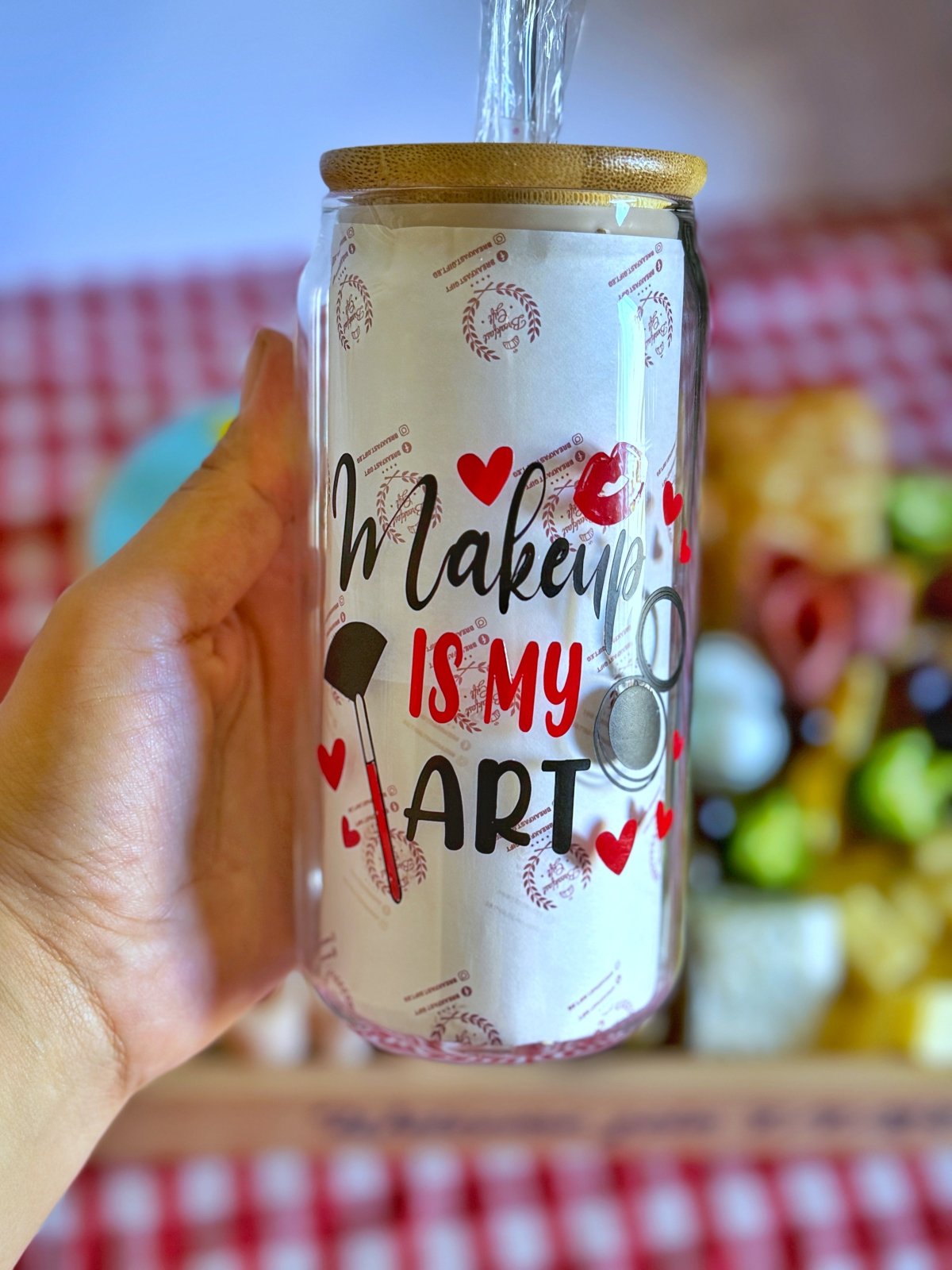 Personalized glass mug with the text "Makeup is my Art" decorated with red hearts and makeup illustrations, featuring a bamboo lid.