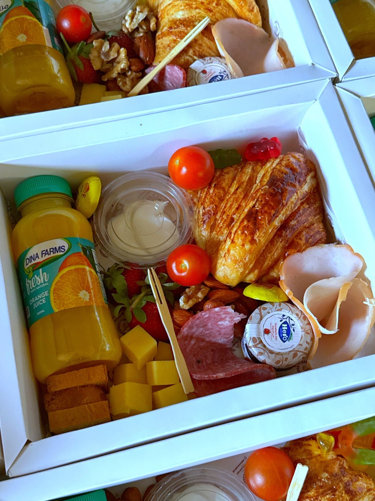 Close-up of the Team Fuel Box showing orange juice, nuts, strawberries, cheddar cubes, and cold cuts inside a white gift box.