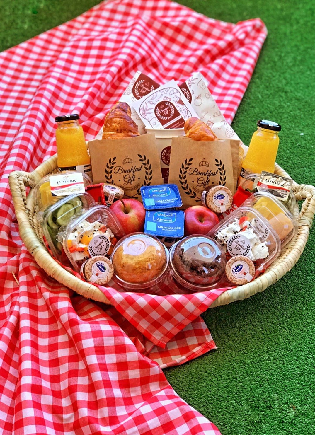 Couples Basic Breakfast in a Basket for Two – an elegantly arranged oval wicker tray featuring flaky croissants, toast, muffins, fresh fruits, cheese, smoked luncheon, natural juices, honey, jam, butter, Kit Kat chocolates, and tea. A perfect breakfast gift for couples, friends, or family.