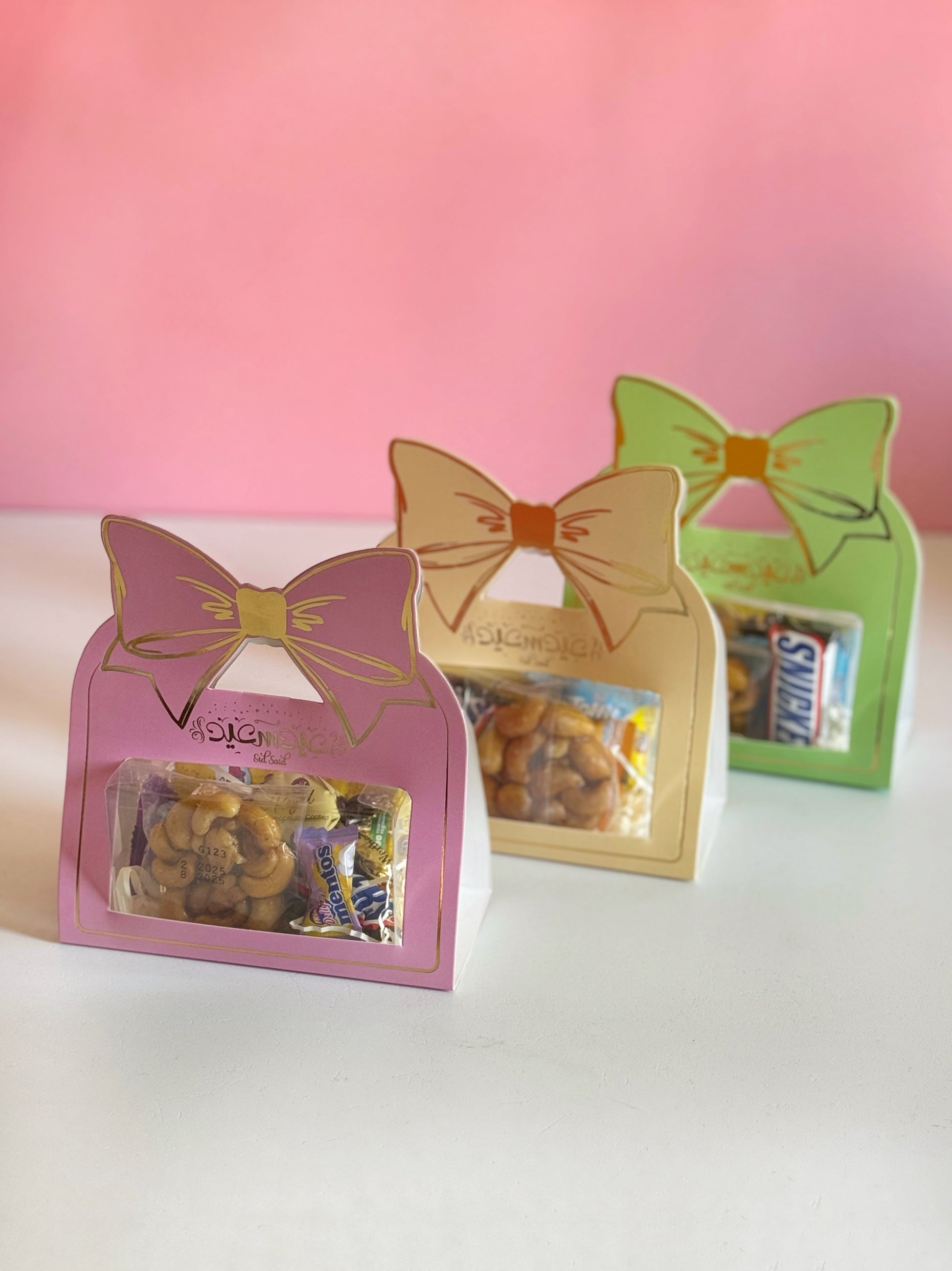 Three Eid Bow Gift Boxes in pink, green, and yellow, beautifully arranged for a festive celebration.