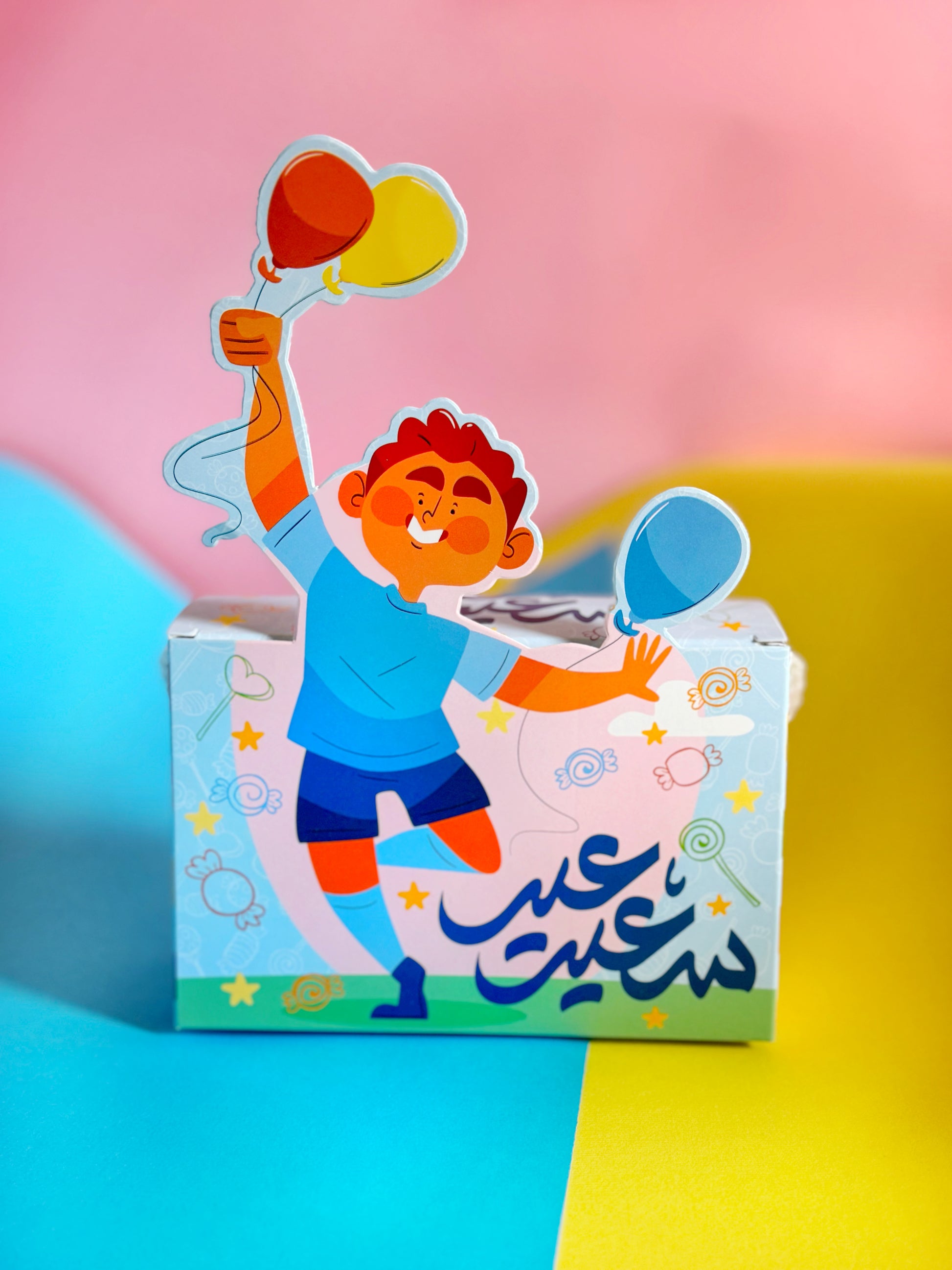 A festive Eid Joy Bag in a boy variant, filled with chocolates, jelly candy, and a water game toy, displayed on a colorful background.