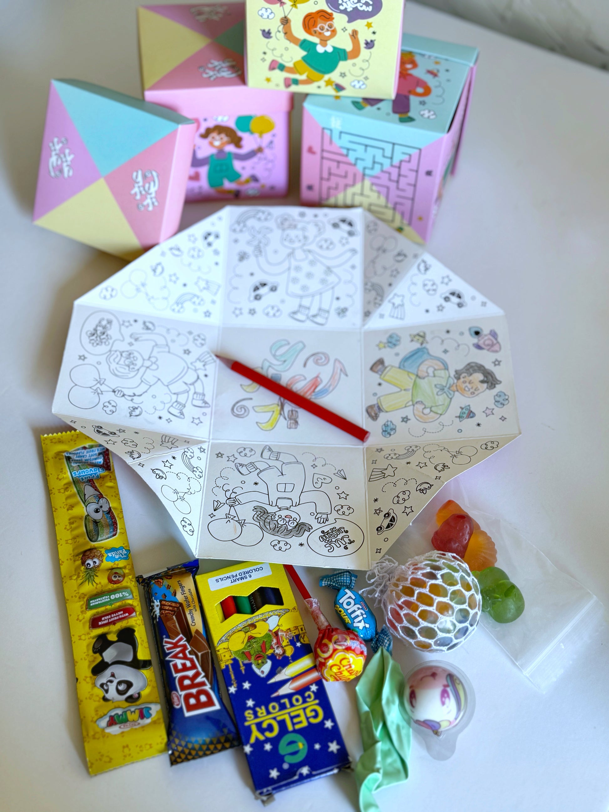 Eid Maze Box opened, displaying an exciting collection of sweets, a bubble toy, a coloring set, and a balloon.