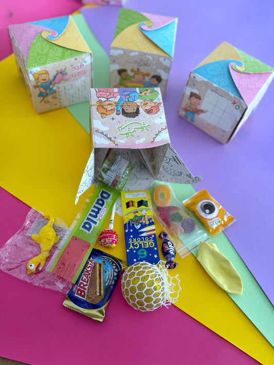Eid Play Cube – Open cube with contents spilling out including Damla Sour Candy Strip, Break Wafer, Pencil Colors, Bead Squishy Ball, and Flying Duck Toy