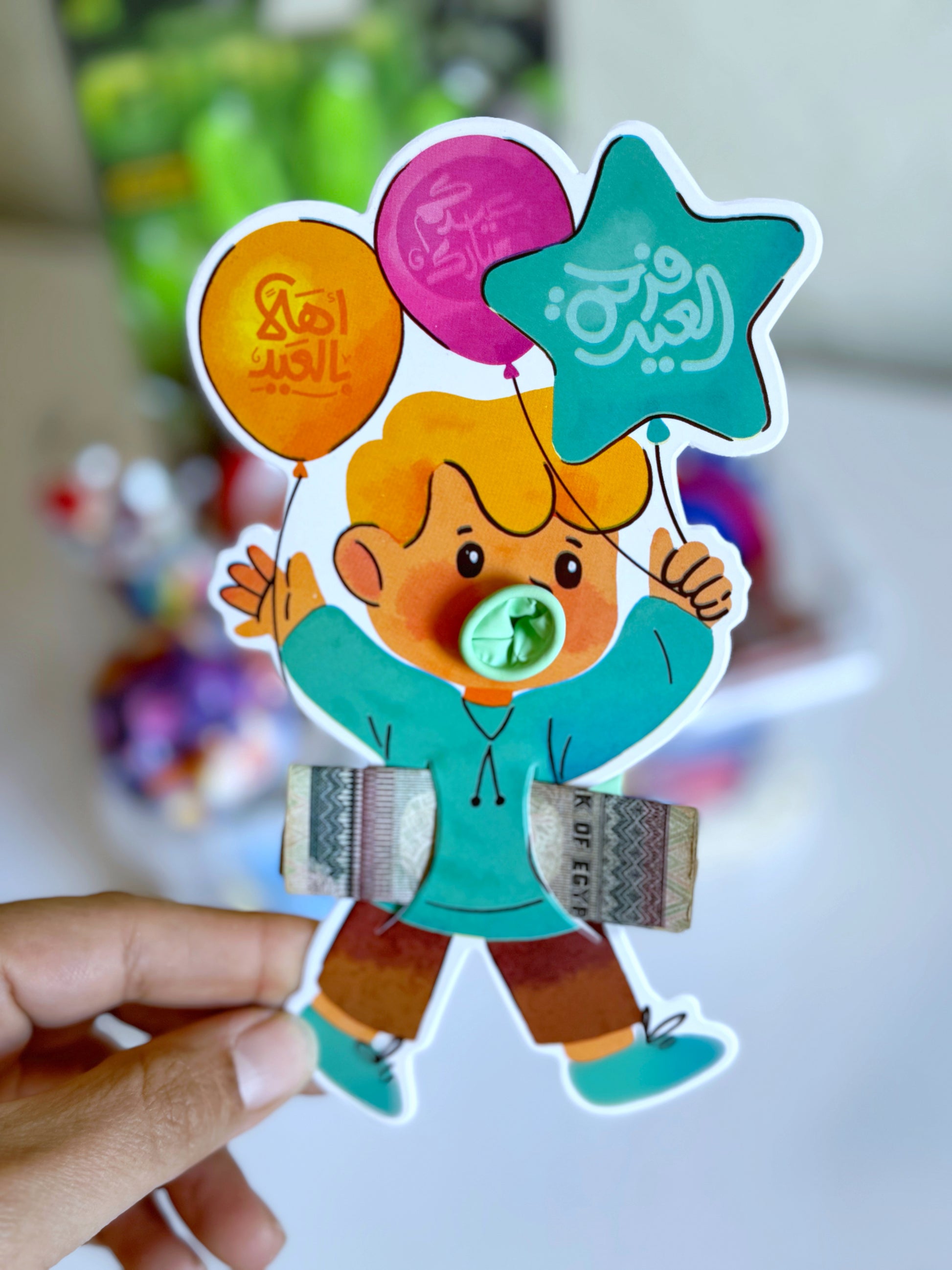 Eidiyya card featuring a playful boy holding colorful balloons, designed to hold cash as part of the Eid gifting tradition.