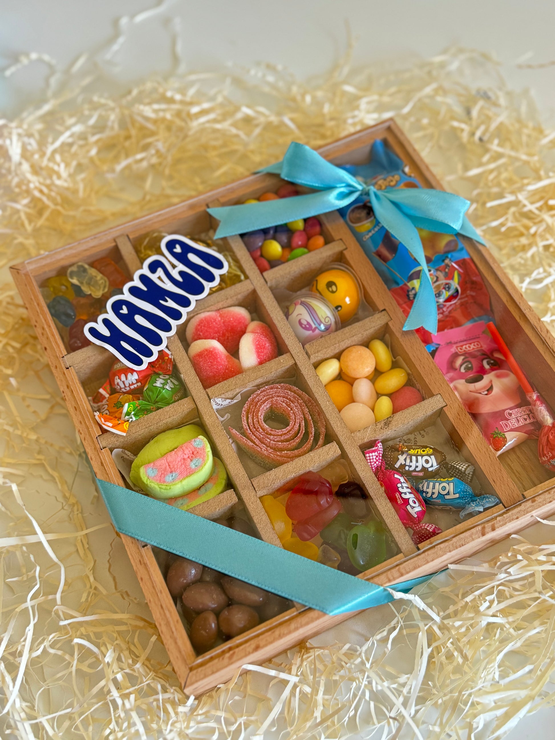 Top view of the Festive Sweets Chest for boys, showcasing assorted jelly candies, bonbons, marshmallows, and a personalized name tag.