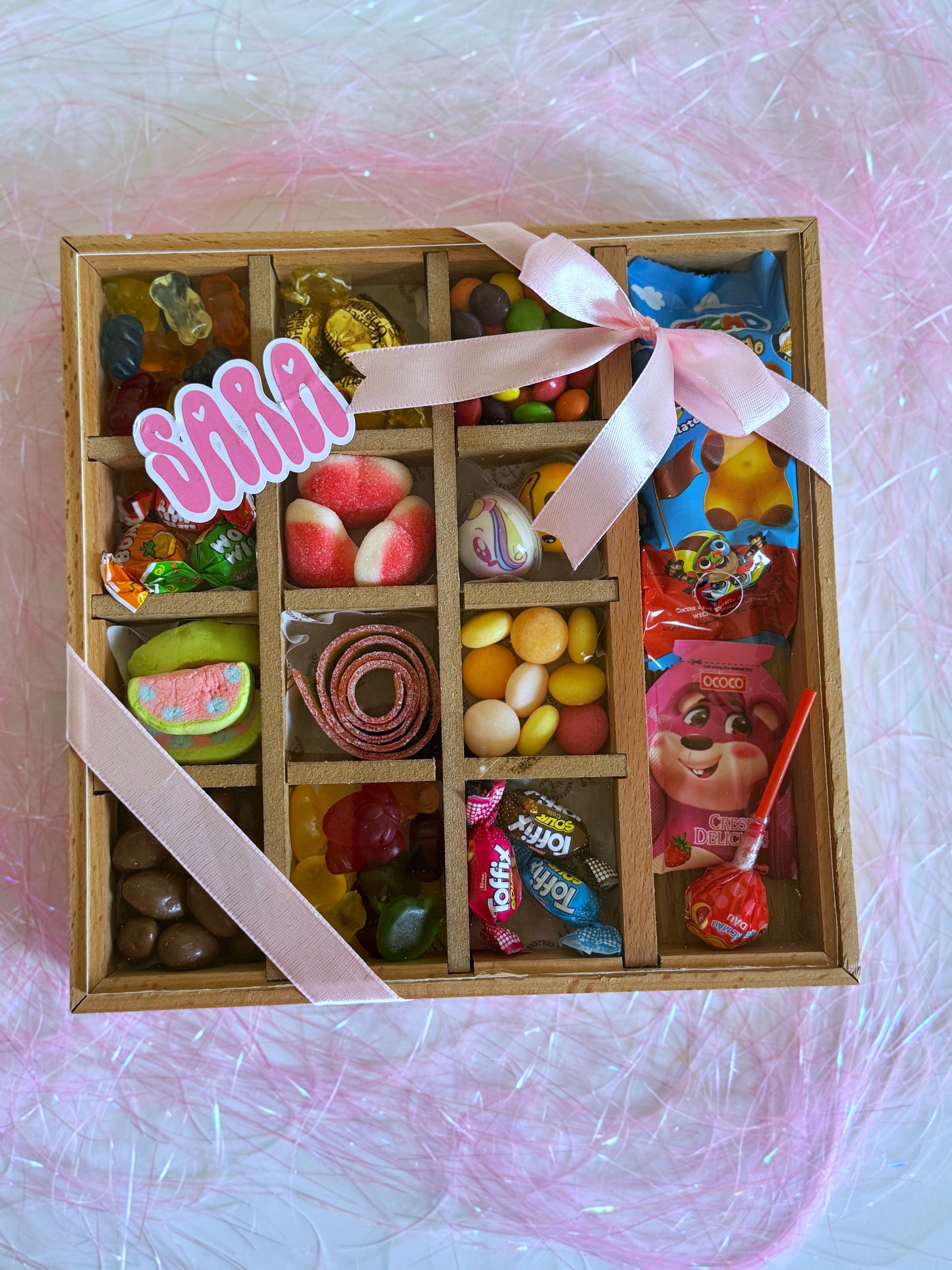 Festive Sweets Chest - Girl, a wooden divided box filled with assorted chocolates, marshmallows, and candies, elegantly presented with a pink ribbon.