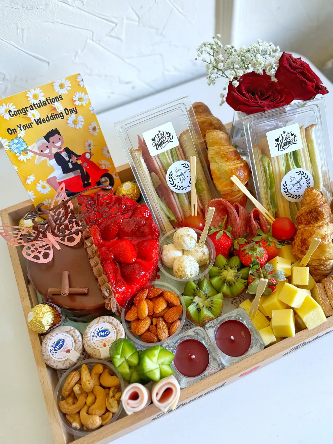 A romantic breakfast tray featuring “Ahmed ❤️ Rehab,” with candles, fruits, cold cuts, and a personalized wedding balloon.