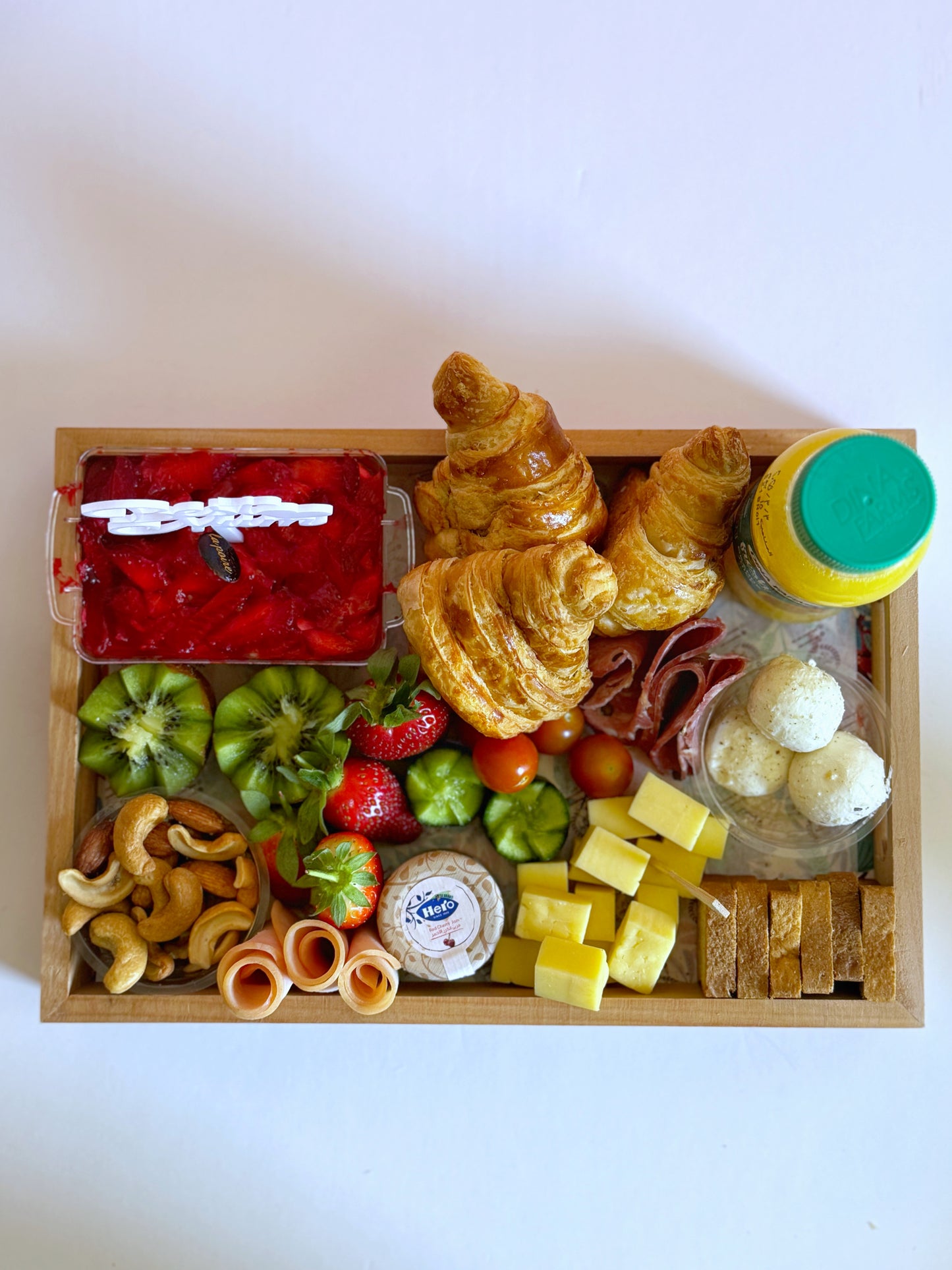 A top view of the Mother's Day breakfast box with fresh pastries, assorted cheeses, cold cuts, and a variety of fresh fruits.