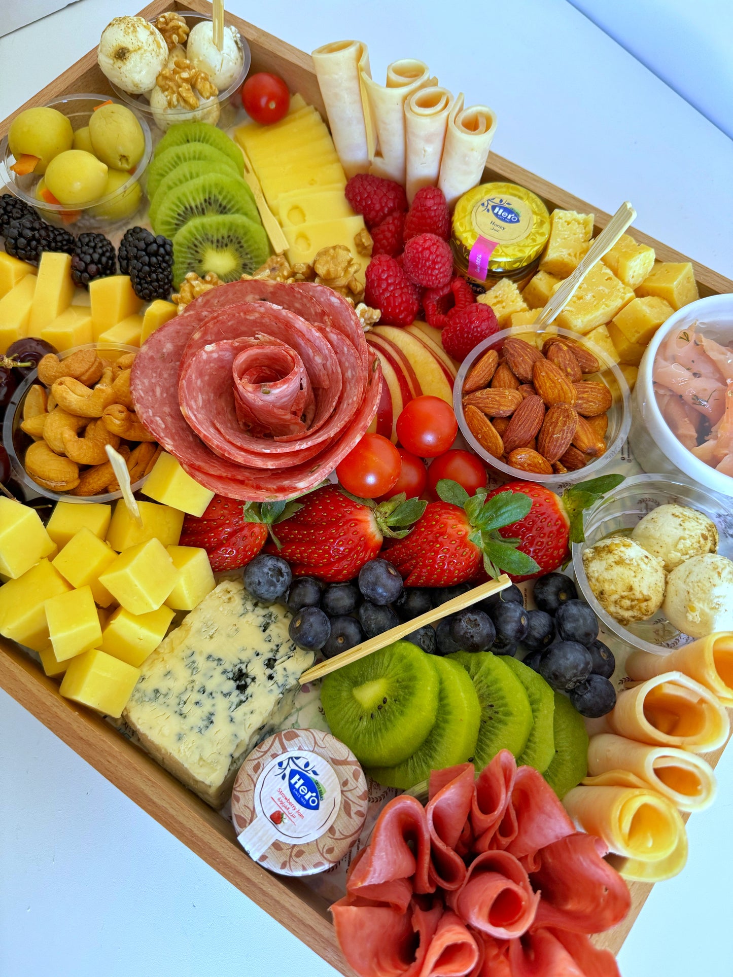 Close-up of the Personalized Gourmet Platter highlighting cold cuts, labneh balls, fresh fruits, and engraved tray details.