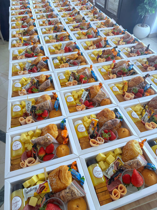 Premium Box – Side-angle view of rows of prepared breakfast boxes laid out on a table