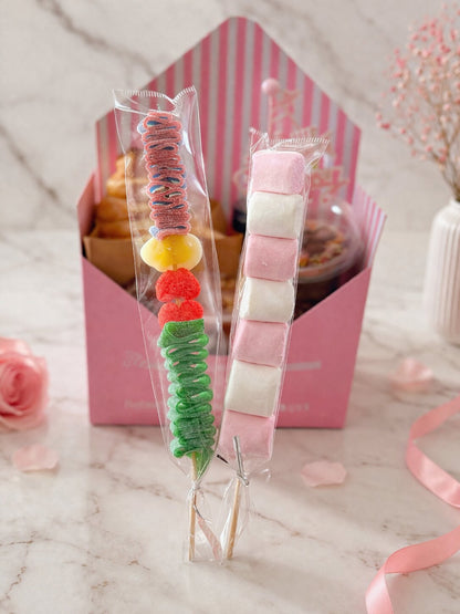 Sweet Birthday Envelope – Close-up of candy skewer and pink-and-white marshmallow skewer in front of the gift box