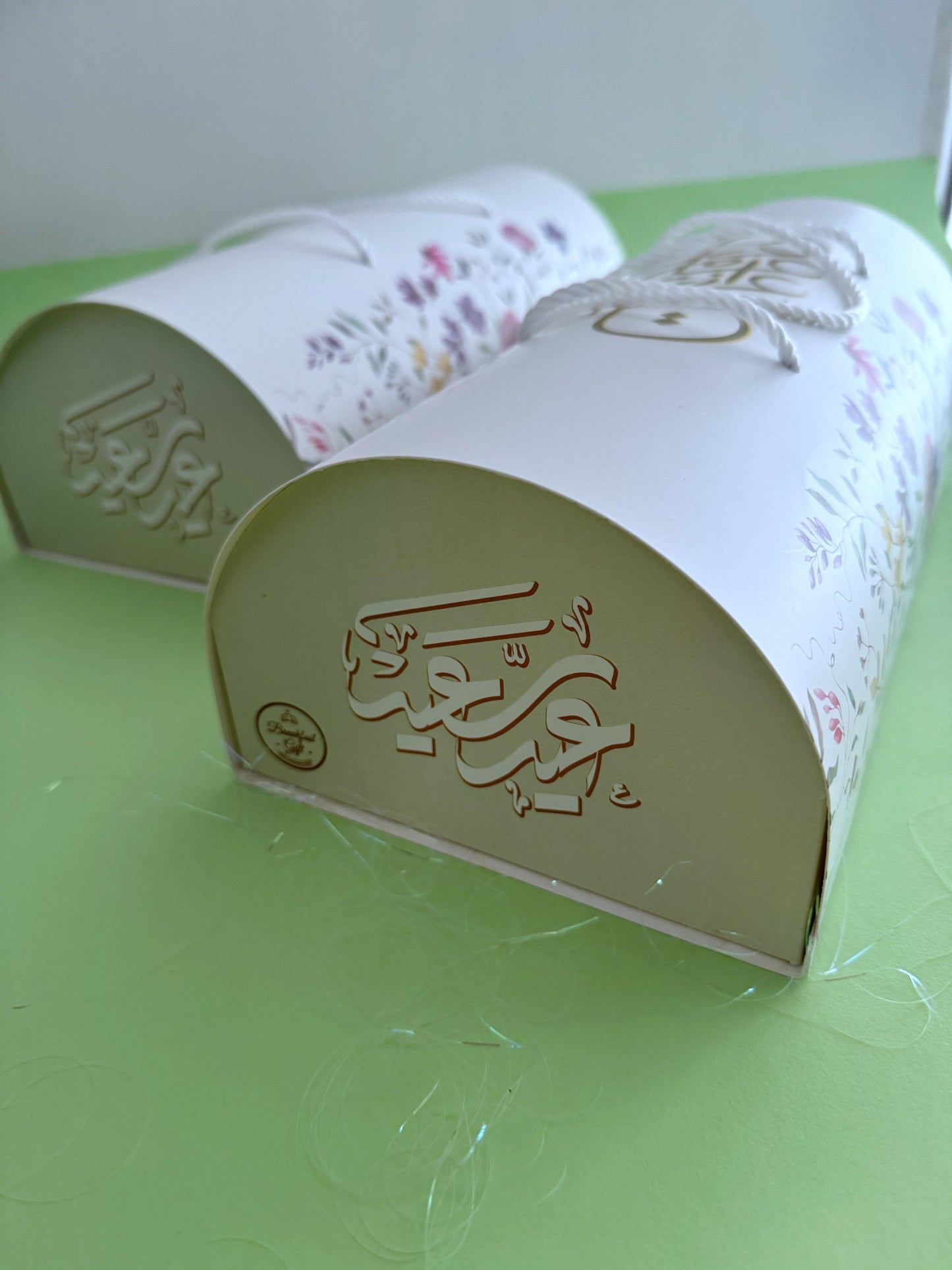 The Grand Kahk Box – Two closed floral cylinder boxes grouped together, arch end view with embossed gold Eid calligraphy