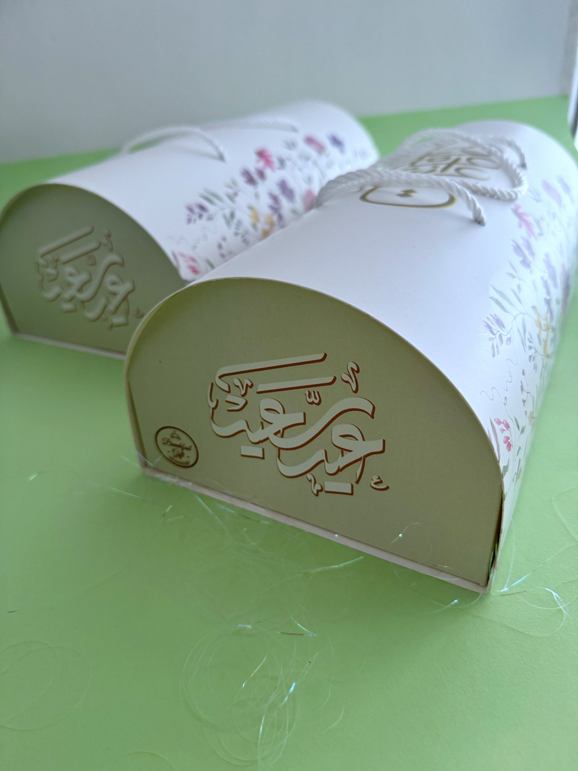 The Grand Kahk Box – Two closed floral cylinder boxes grouped together, arch end view with embossed gold Eid calligraphy
